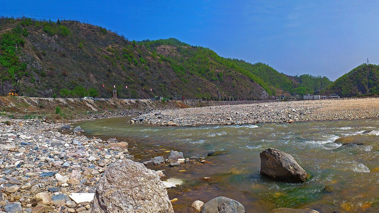 山谷中的河流、河滩与沿河公路，远处是秦岭余脉